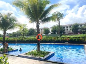 a pool with a palm tree and a life preserver at Cat Lai Garden Villa in Ho Chi Minh City