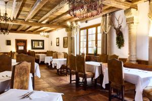 a dining room with tables and chairs and a chandelier at Logis Hotel Domaine de Rouffach in Rouffach