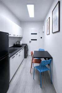 a kitchen with a table and chairs and a black refrigerator at Przystanek Wałbrzych in Wałbrzych
