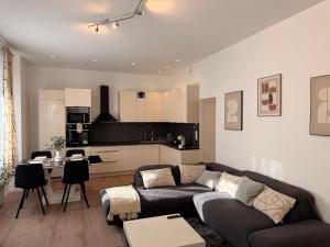 a living room with a couch and a kitchen at Superbe 4 pièces luxueux in Fleury-les-Aubrais
