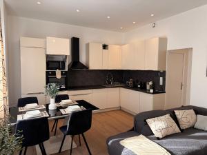 a kitchen with a couch and a table in a living room at Superbe 4 pièces luxueux in Fleury-les-Aubrais +18 photos