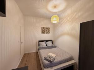 a small bedroom with a bed and a light at Superbe 4 pièces luxueux in Fleury-les-Aubrais