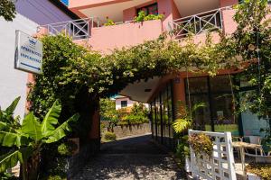 a pink building with flowers on a balcony at Aparthotel Imperatriz in Funchal
