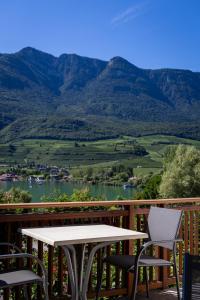 a table and chairs on a deck with a view of a mountain at Gass-Hof in Caldaro