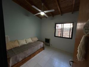 a bedroom with a bed and a ceiling fan at La Casita de Levene en Lobos in Lobos