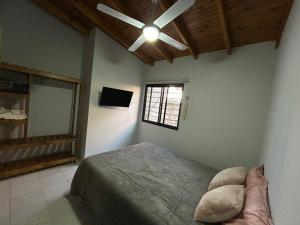 a bedroom with a bed and a ceiling fan at La Casita de Levene en Lobos in Lobos