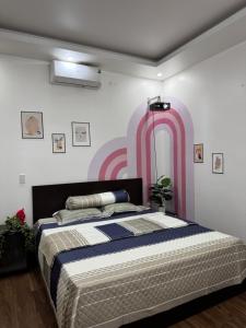 a bedroom with a bed with a pink and white wall at 05 Homestay Cinema in An Khê +17 photos