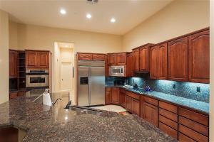 a kitchen with wooden cabinets and a stainless steel refrigerator at Caledonia Dreamin in Phoenix +26 photos