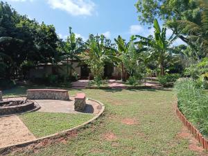 a garden with a bench and trees at Aachchi Country Home by ABC Leisure's group in Jaffna