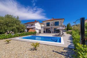 a villa with a swimming pool in front of a house at Villa MARIS with private pool in Sveti Vid-Miholjice