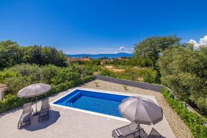 a swimming pool with two umbrellas and two chairs at Villa MARIS with private pool in Sveti Vid-Miholjice