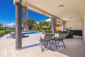 a patio with chairs and a table and a pool at Villa MARIS with private pool in Sveti Vid-Miholjice +27 photos