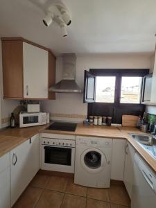 a kitchen with a washing machine and a sink at Casa Velez in Vélez de Benaudalla +22 photos