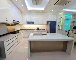 a large kitchen with white cabinets and a sink at Large Group KTV Stay, Near Setia Alam, Klang in Klang