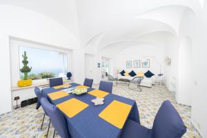 a dining room with a blue and yellow table and chairs at Villa La Panoramica Sea View in Capri