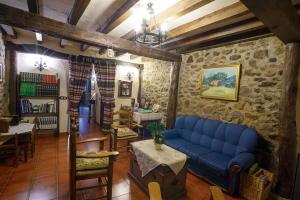 sala de estar con sofá azul y mesa en Apartamentos Rurales Tía Josefa, en Tornavacas