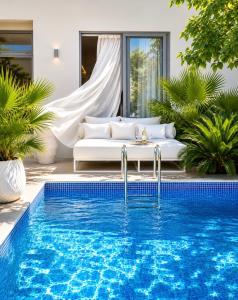 a pool in front of a villa with a couch at Villa Almihauss - Adults Only in Afantou