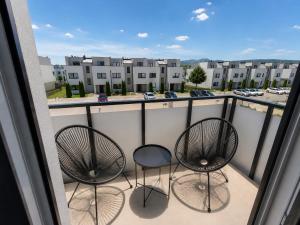 a balcony with two chairs and a view of a parking lot at Luxury White Residence in Trenčín