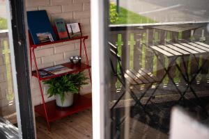 ein rotes Regal auf einem Balkon mit einem Stuhl in der Unterkunft Zunda in Nida