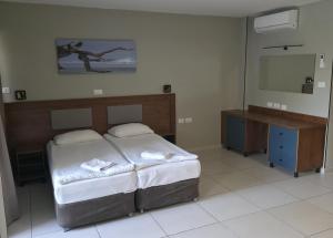 a bedroom with a bed and a television in it at Regina Goren Hotel in Ashkelon