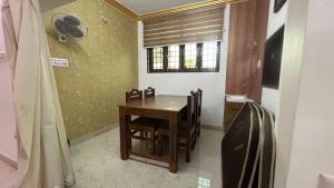 a dining room with a wooden table and chairs at Sangeetha Private Pool Villa in Auroville