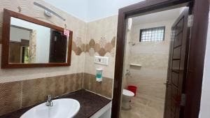 a bathroom with a sink and a mirror and a toilet at Sangeetha Private Pool Villa in Auroville +18 photos