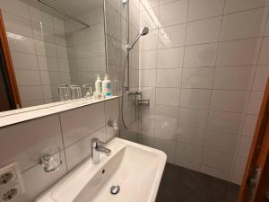 a white bathroom with a shower and a sink at Residenz Dunza Hotel Garni in Bürserberg +47 photos