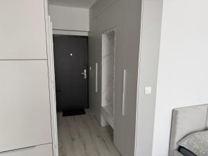 a mirror reflecting a hallway with a black door at Luxury White Residence in Trenčín
