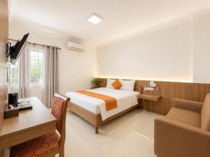 a hotel room with a bed and a desk and a chair at The One by Nika in Siem Reap