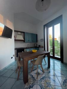 a kitchen with a wooden table and two chairs at Sibilla Flegrea in Pozzuoli
