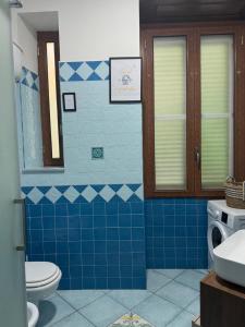a blue tiled bathroom with a toilet and a sink at Sibilla Flegrea in Pozzuoli