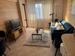 a living room with a blue couch and a tv at Sun Sea Resort in Ravda