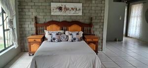 a bedroom with a bed with a wooden head board at Daisy Lodge in Barberton +18 photos