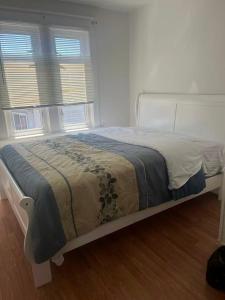 a white bed in a room with two windows at six bedroom house in Victoria