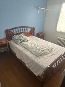 a bed in a bedroom with two tables and a window at Malkom house in Gien