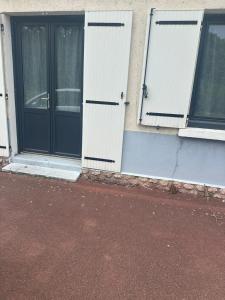 two doors on the side of a building at Malkom house in Gien