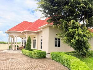 a house with a red roof and a brick driveway at Volcanoes Stay Musanze in Kigali