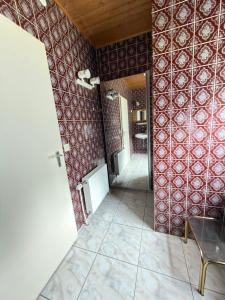 a room with red walls and a tile floor and a hallway at Monteur Budget Zimmer in Schöppenstedt