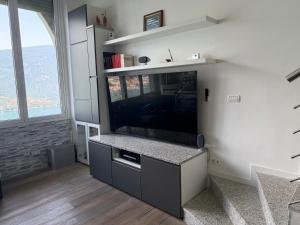 a living room with a large flat screen tv at Appartamenti Lago di Como in Valbrona