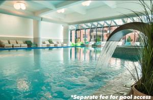 a swimming pool with a fountain in a building at Alpine Line Studio with pool & spa in Sinaia