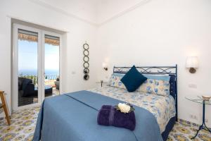 a bedroom with a bed with a blue comforter at Villa La Panoramica Sea View in Capri