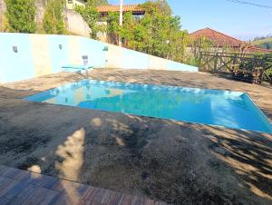 a swimming pool in the middle of a yard at Linda Chácara Próxima a Monte Verde in Camanducaia