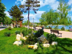 a park with benches and rocks in the grass at Apartament Eduard in Techirghiol