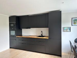 a kitchen with black cabinets and a sink at Laitselossi tee Apartment in Laitse