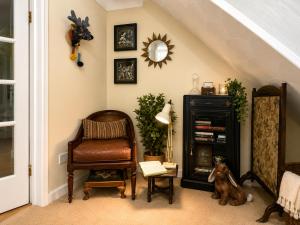 a living room with a chair and a mirror at Two Ducks Cottage by NewFo dot Rest in Lyndhurst