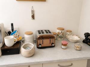 a kitchen counter with a toaster and other kitchen items at Two Ducks Cottage by NewFo dot Rest in Lyndhurst