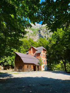 ein großes Gebäude vor einem Berg im Hintergrund in der Unterkunft Riverside in Valbonë
