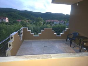 a balcony with stairs and a table and chairs at Sofija in Radanovići