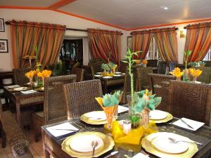 a dining room with tables and chairs with flowers on them at Castle Lodge in Boksburg