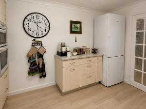 a kitchen with a large clock on the wall at Two Ducks Cottage by NewFo dot Rest in Lyndhurst